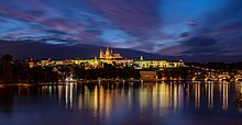 Le château de Prague se reflétant dans la Vltava depuis son éperon rocheux.